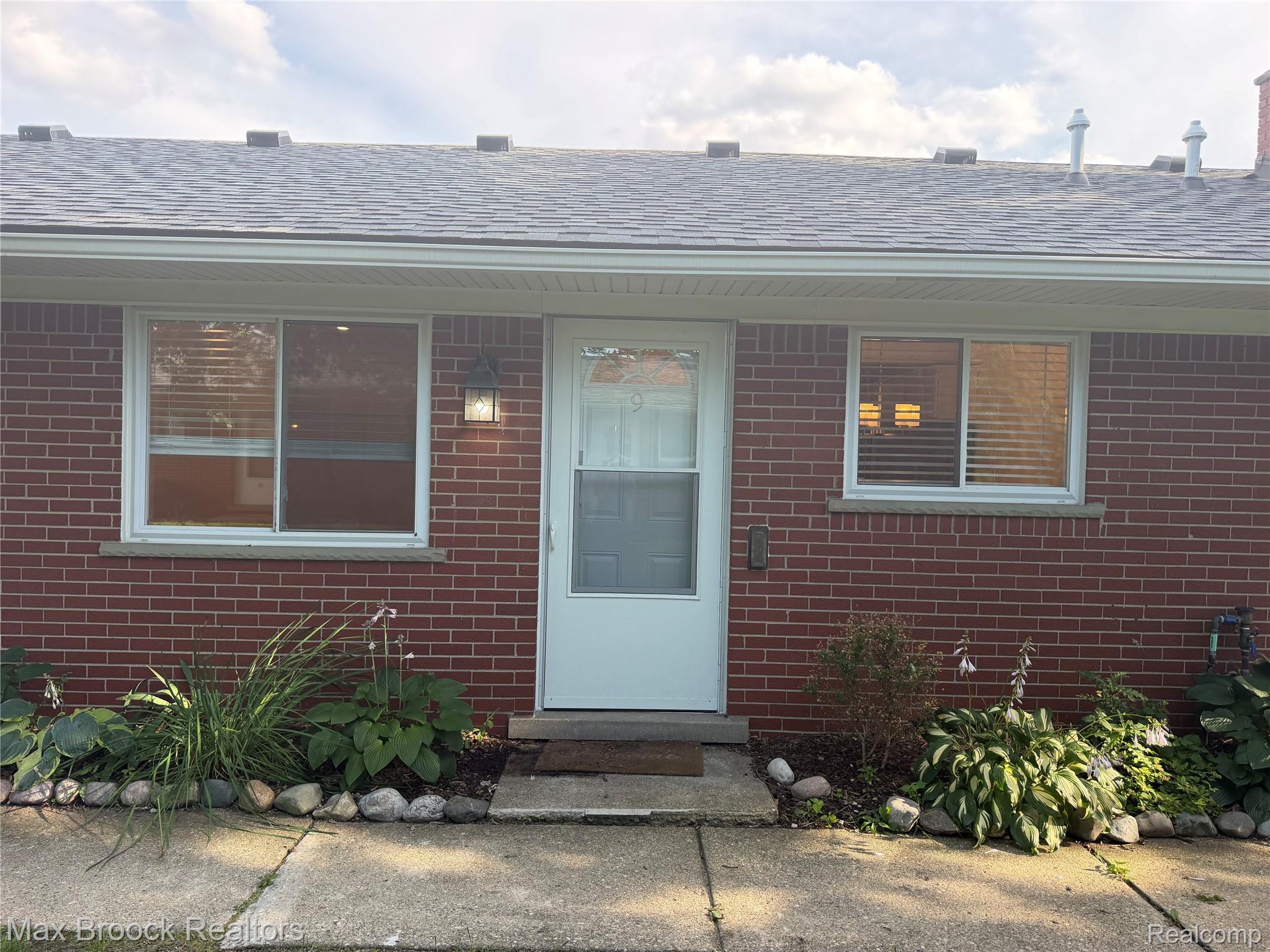 3875 Devon Road, Unit # 9 Royal Oak, MI 48073 - Photo 3 of 17 Brick exterior featuring white trim and a gray shingle roof