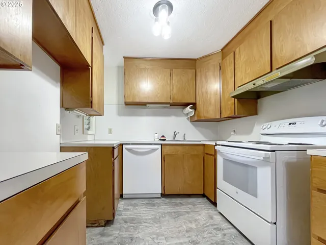 a kitchen with stainless steel appliances granite countertop a sink stove and cabinets