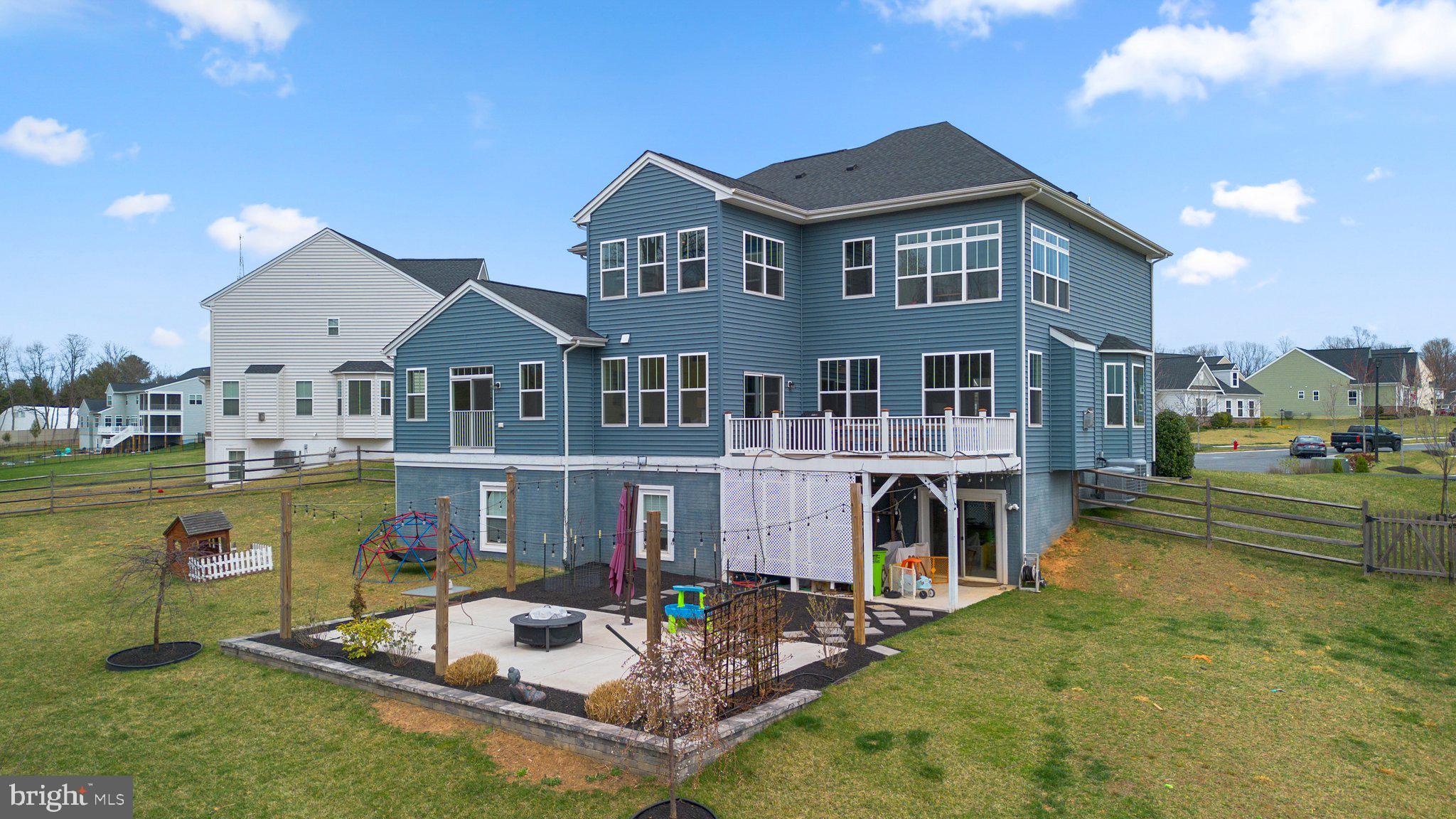 18608 Compher Court Poolesville, MD 20837 - Photo 29 of 40 a front view of a house with swimming pool lawn chairs and a fire pit