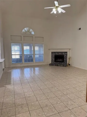 an empty room with fireplace and windows