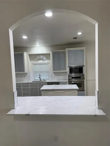 a view of kitchen with stainless steel appliances cabinets