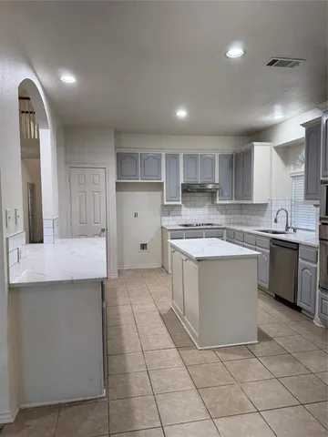 a kitchen with a stove a sink and a refrigerator