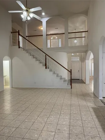 a view of staircase with white walls and a chandelier