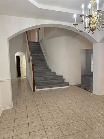 a view of a hallway with entryway and chandelier