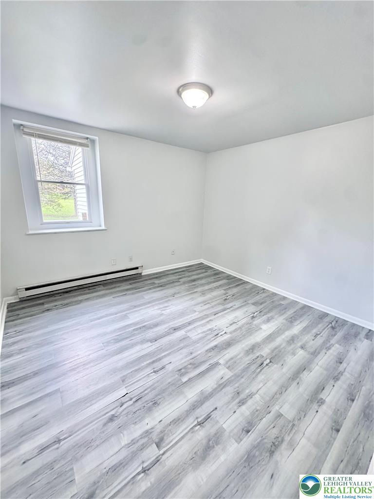 8361 Schantz Road, Unit 1 Breinigsville, PA 18031 - Photo 8 of 18 an empty room with wooden floor and window