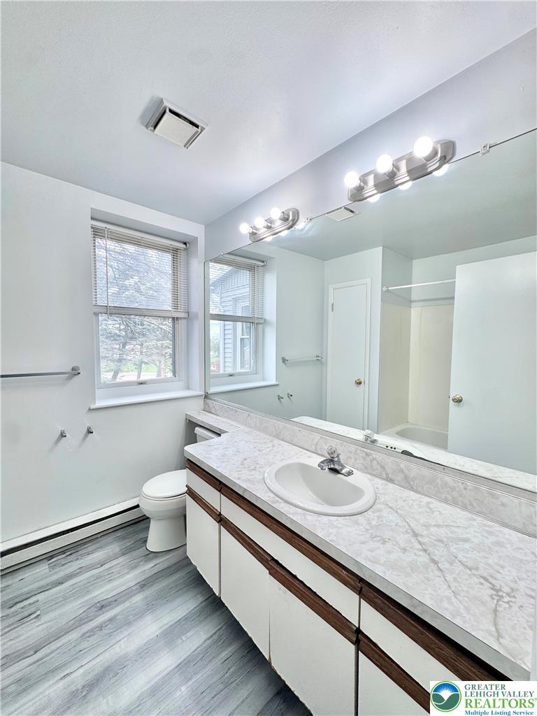8361 Schantz Road, Unit 1 Breinigsville, PA 18031 - Photo 10 of 18 a bathroom with a granite countertop sink a large mirror and a window