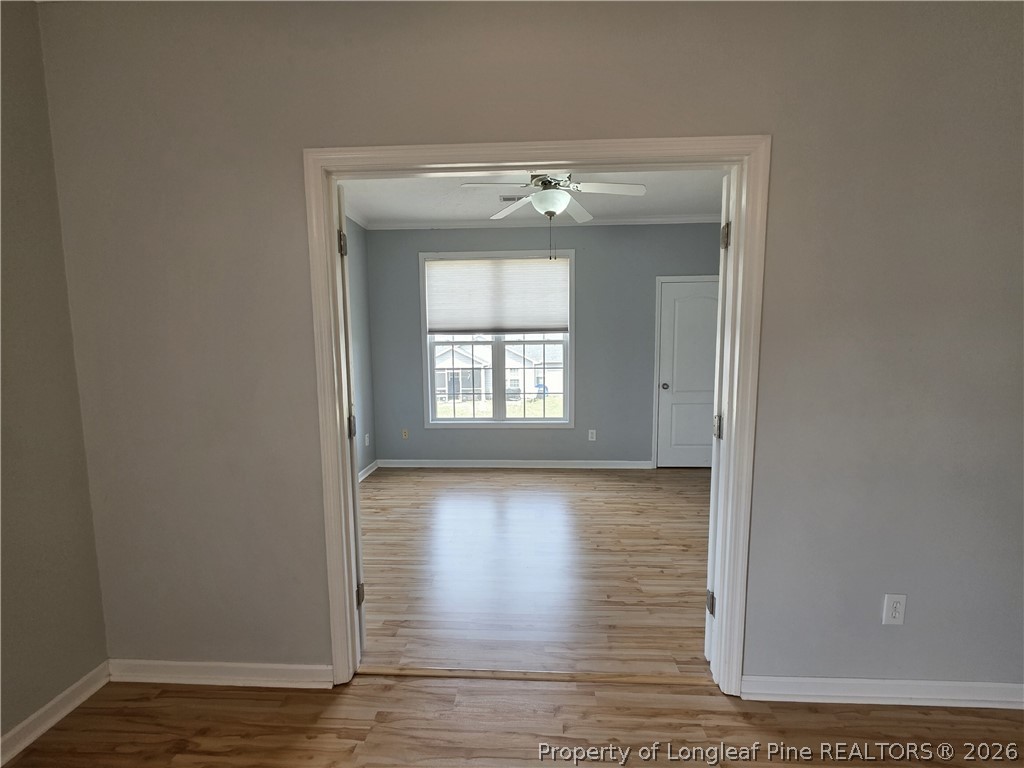 1324 Kershaw Loop, Unit 206 Fayetteville, NC 28314 - Photo 13 of 26 a view of an empty room with wooden floor and a window