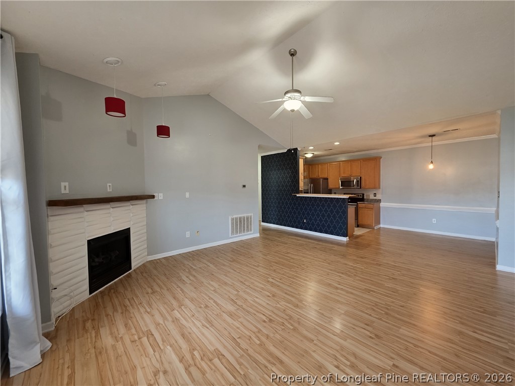1324 Kershaw Loop, Unit 206 Fayetteville, NC 28314 - Photo 7 of 26 an empty room with wooden floor fireplace and windows