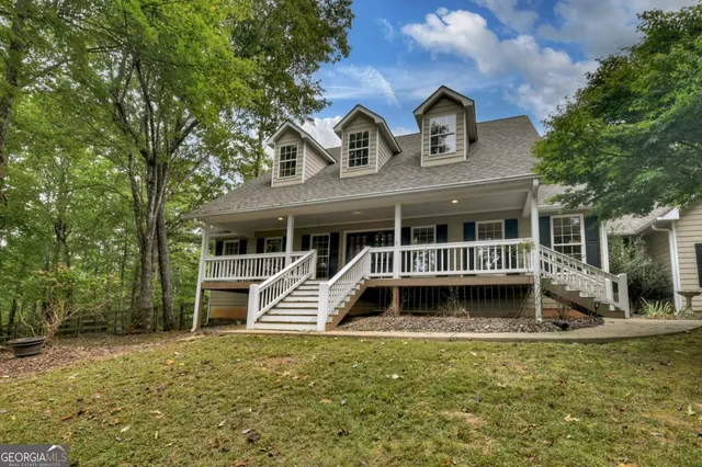 a view of an empty room with wooden floor fireplace and a window