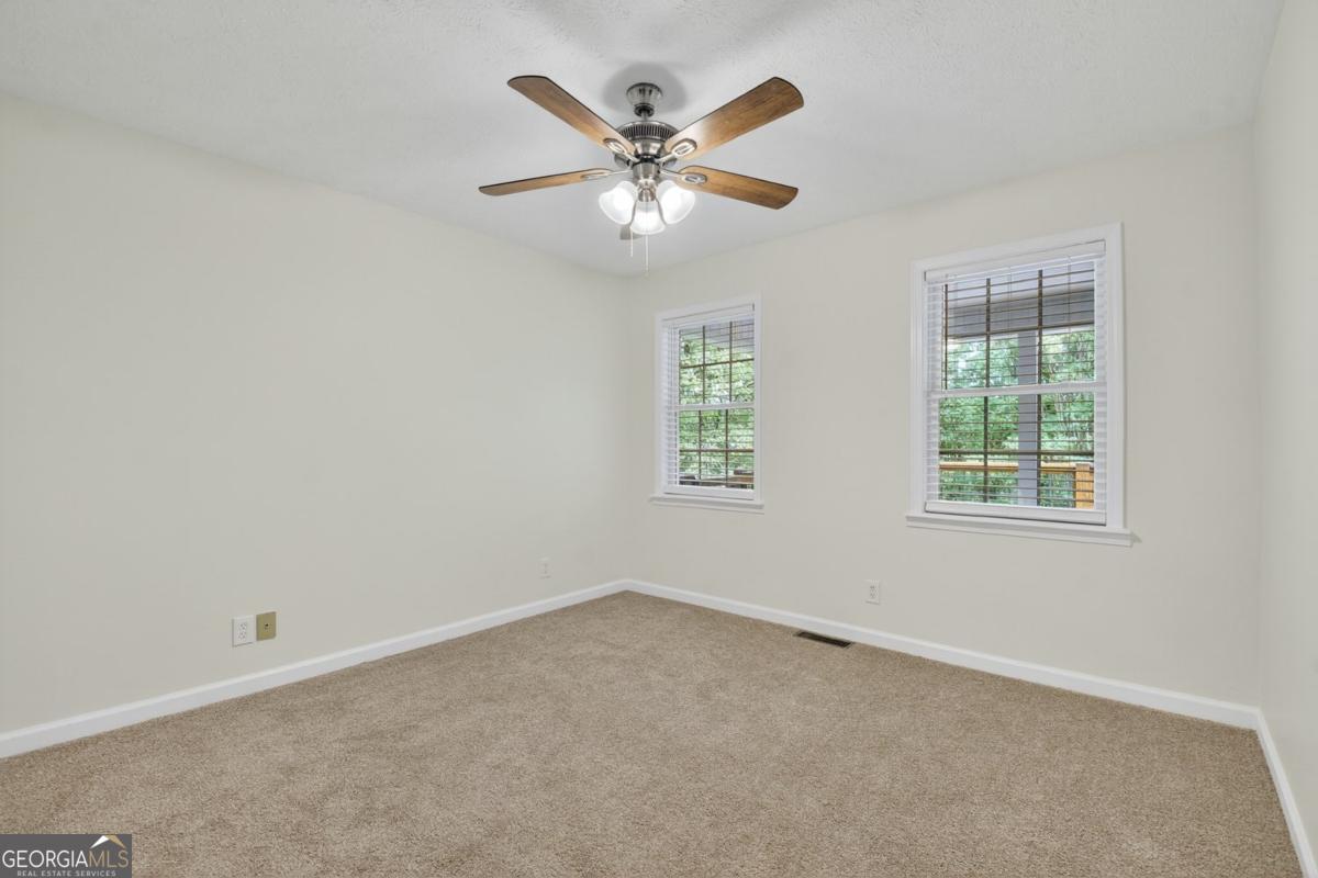 344 Cascade Lane Blue Ridge, GA 30513 - Photo 39 of 62 an empty room with a ceiling fan and windows