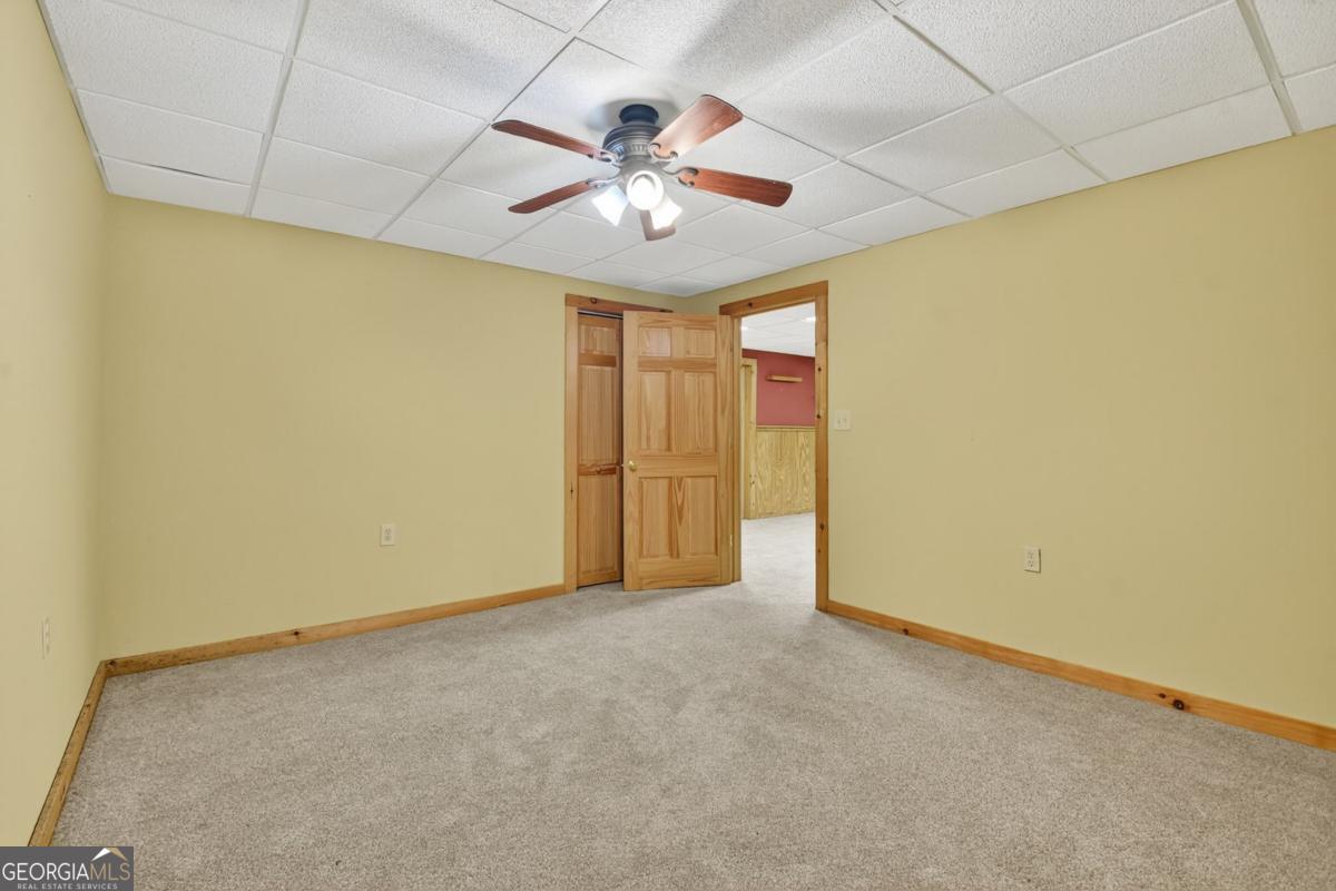 344 Cascade Lane Blue Ridge, GA 30513 - Photo 55 of 62 an empty room with a ceiling fan and a large window