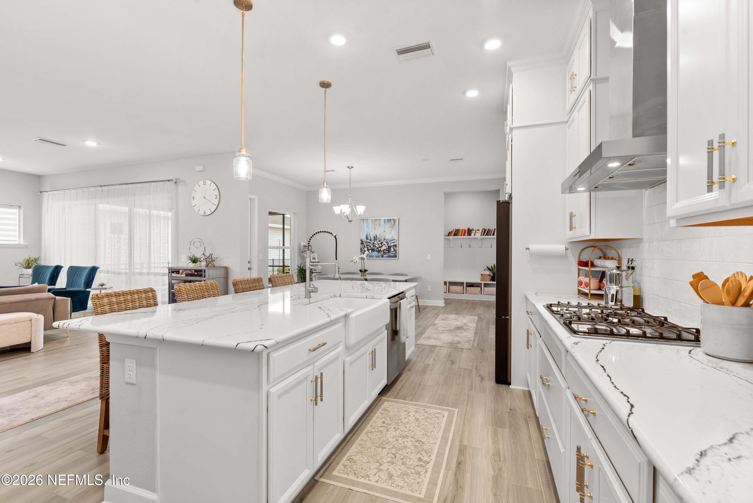 5270 Piney Flats Road Jacksonville, FL 32224 - Photo 19 of 53 a large kitchen with stainless steel appliances kitchen island a large counter top a stove a chimney a sink and a living room view