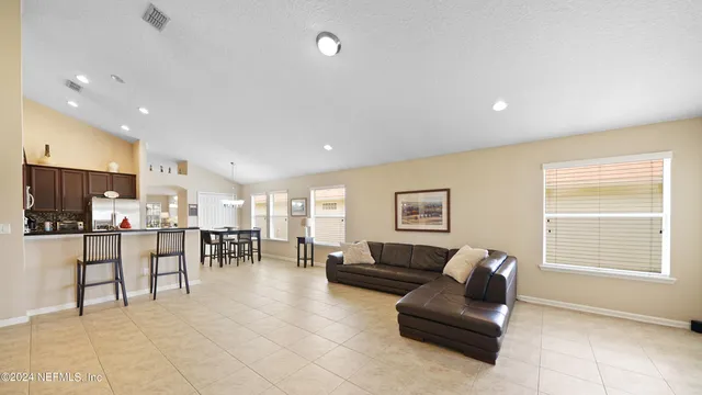 a living room with furniture and a dining table with kitchen view