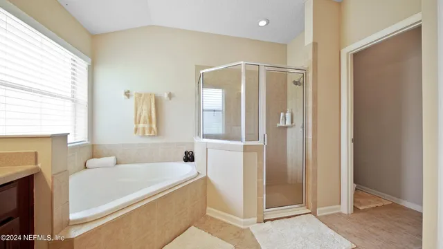 a spacious bathroom with a tub shower and mirror