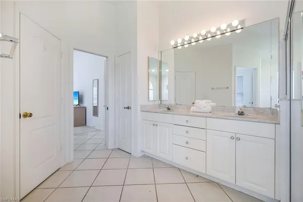 a spacious bathroom with a double vanity sink a mirror and a