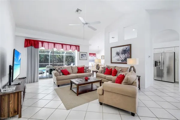 a living room with furniture a flat screen tv and a large window
