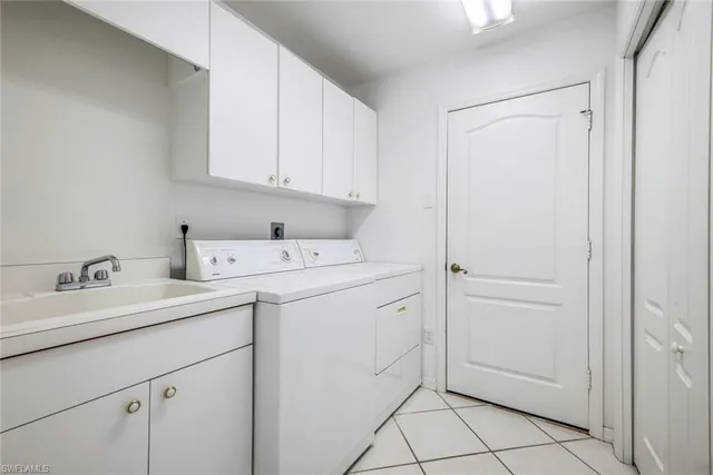 a utility room with cabinets washer and dryer