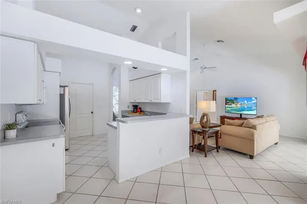 a living room with furniture and a refrigerator