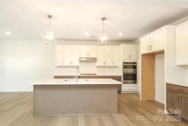 a large kitchen with kitchen island a sink stainless steel appliances and cabinets