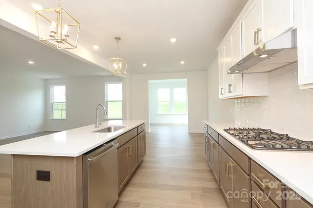 a large kitchen with kitchen island a sink stainless steel appliances and cabinets