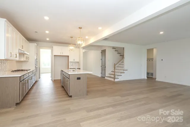 a large kitchen with stainless steel appliances kitchen island a large counter top and a stove top oven