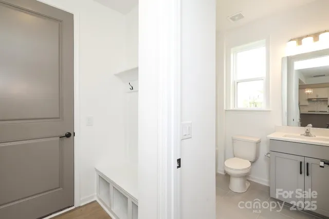 a bathroom with a toilet a sink and a mirror