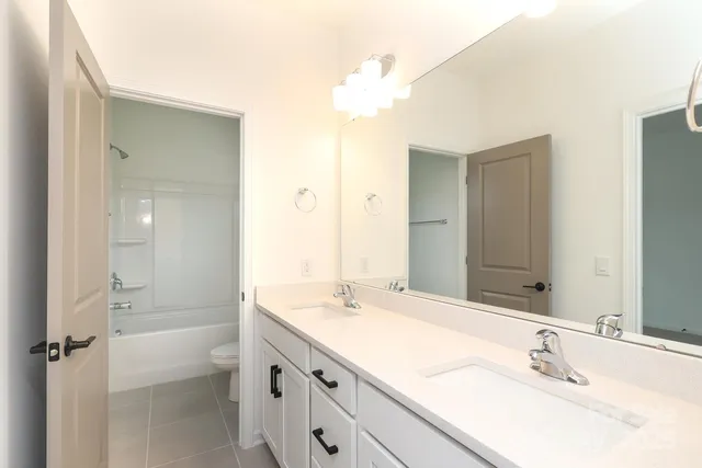 a bathroom with a bathtub shower sink vanity and mirror