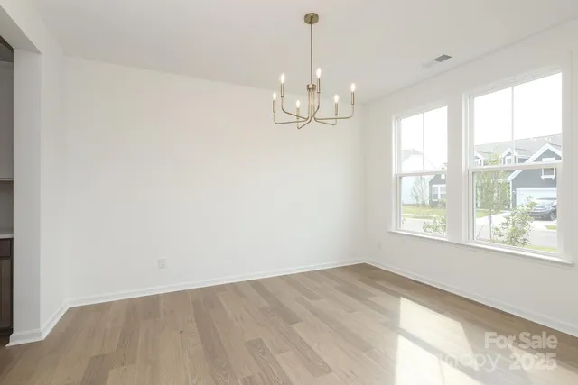 a view of a big room with wooden floor and windows