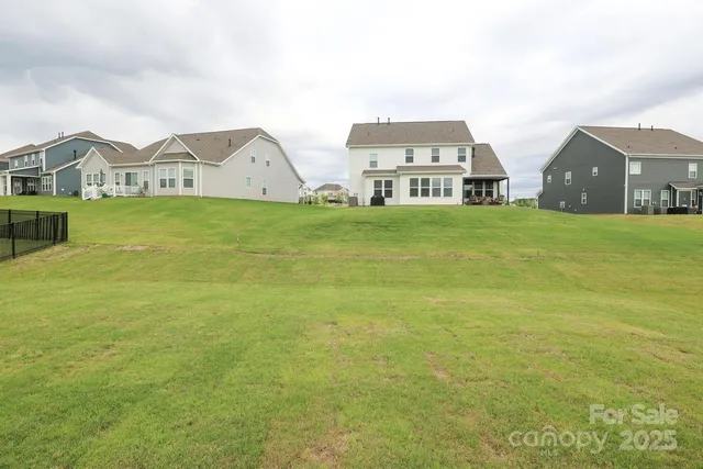 a view of a big house with a big yard and large trees