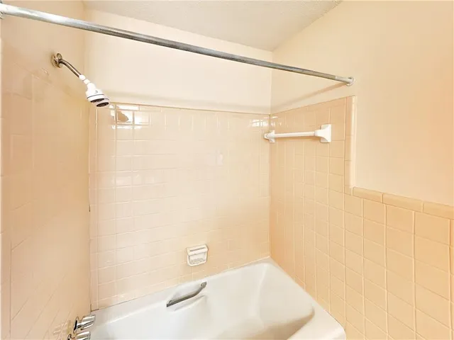 a bathroom with a white bath tub and a shower