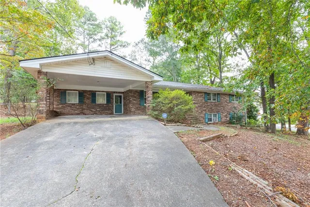a view of a house with a yard and large tree