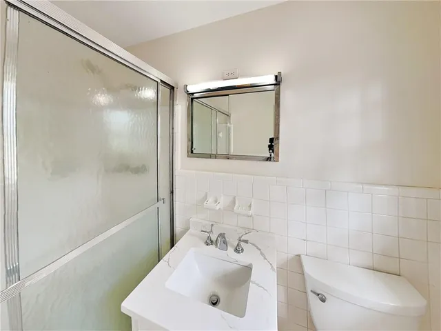 a bathroom with a sink mirror and toilet