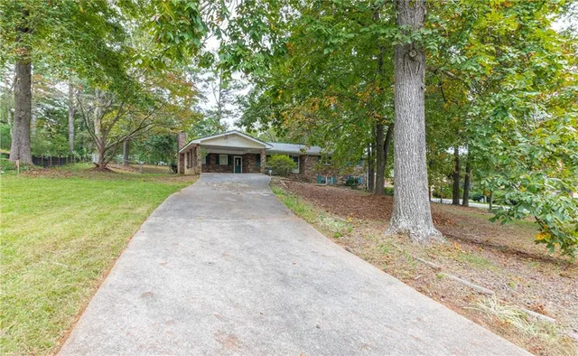 a view of a house with backyard and trees