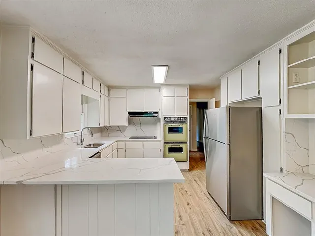 a kitchen with stainless steel appliances a refrigerator sink and microwave