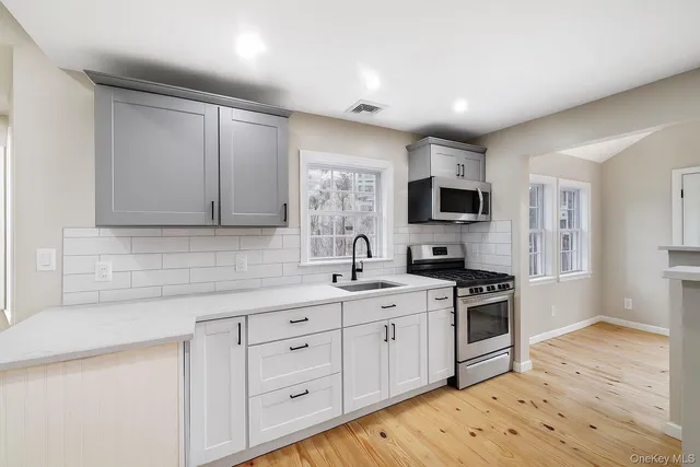 a large kitchen with stainless steel appliances kitchen island granite countertop a sink and cabinets