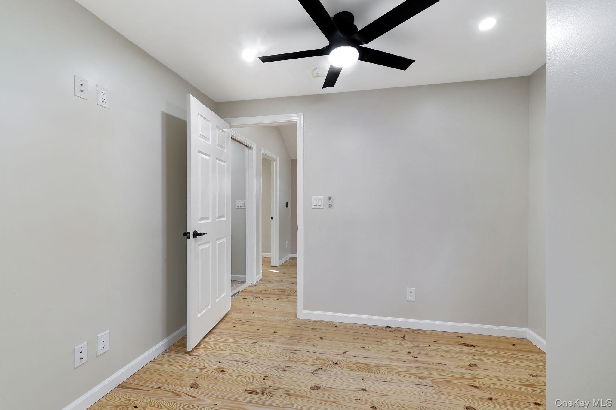 80 Kitz Road Monticello, NY 12701 - Photo 18 of 39 an empty room with wooden floor fan and windows