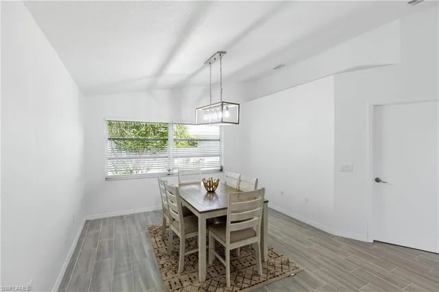 a dining room with wooden floor and a window