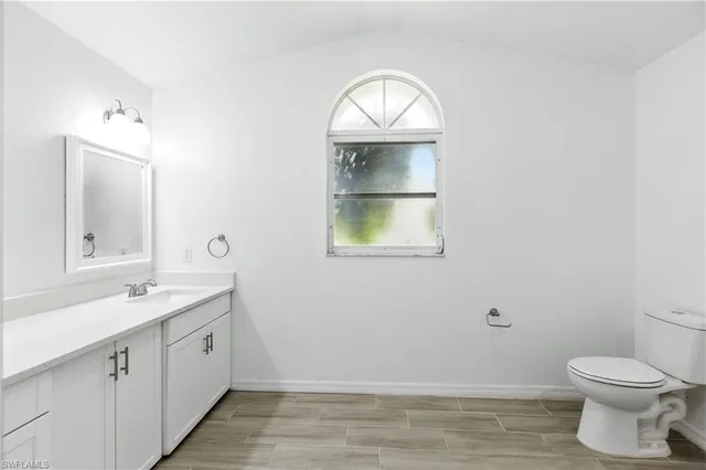 a bathroom with a toilet sink vanity and mirror