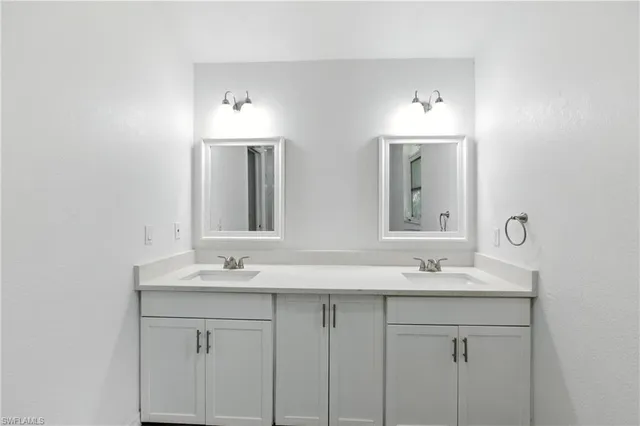 a bathroom with double sink and a mirror