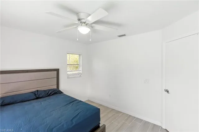 a room with a dresser and a chandelier fan