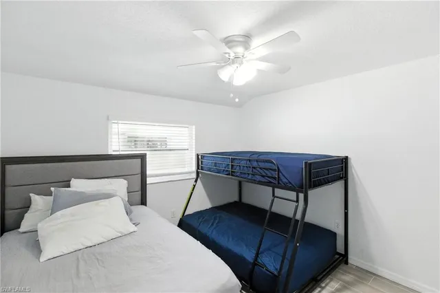a bedroom with a bed window and a chandelier