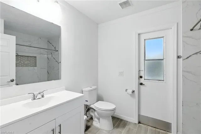 a bathroom with a granite countertop sink toilet and shower