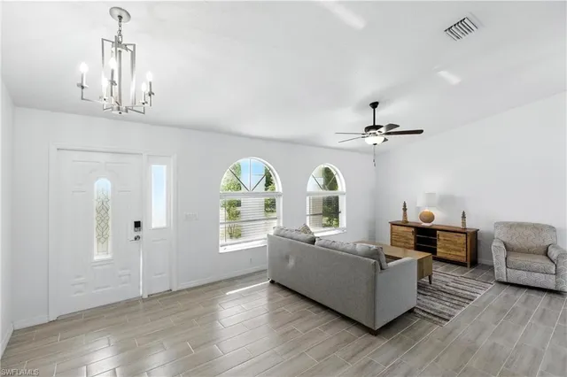 a living room with furniture and a chandelier