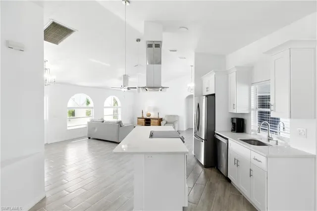 a kitchen with stainless steel appliances a refrigerator sink and white cabinets