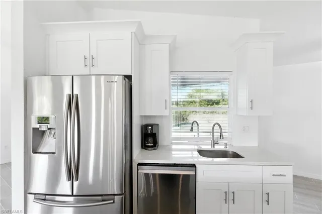 a kitchen with stainless steel appliances a refrigerator sink and cabinets