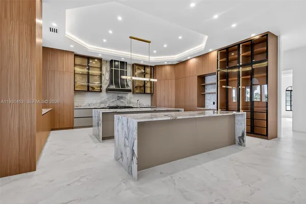 a large kitchen with stainless steel appliances kitchen island granite countertop a refrigerator and a stove top oven