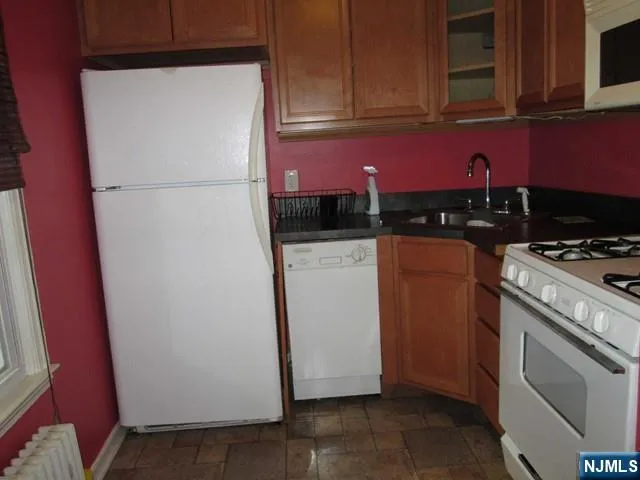 a kitchen with a refrigerator a stove top oven a sink and cabinets