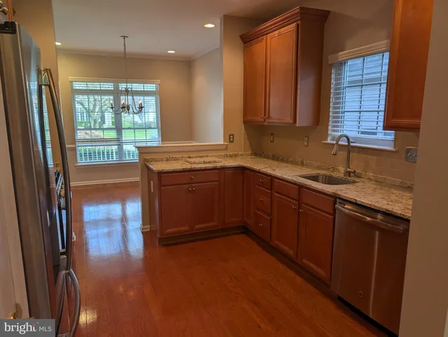 a kitchen with a sink wooden cabinets and a large window