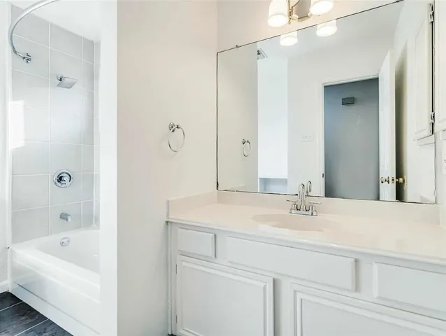 a bathroom with a tub a sink and mirror