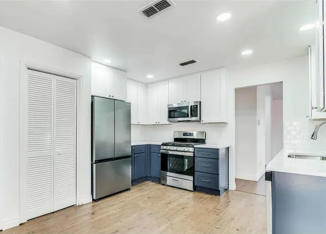 a kitchen with stainless steel appliances a refrigerator and a stove